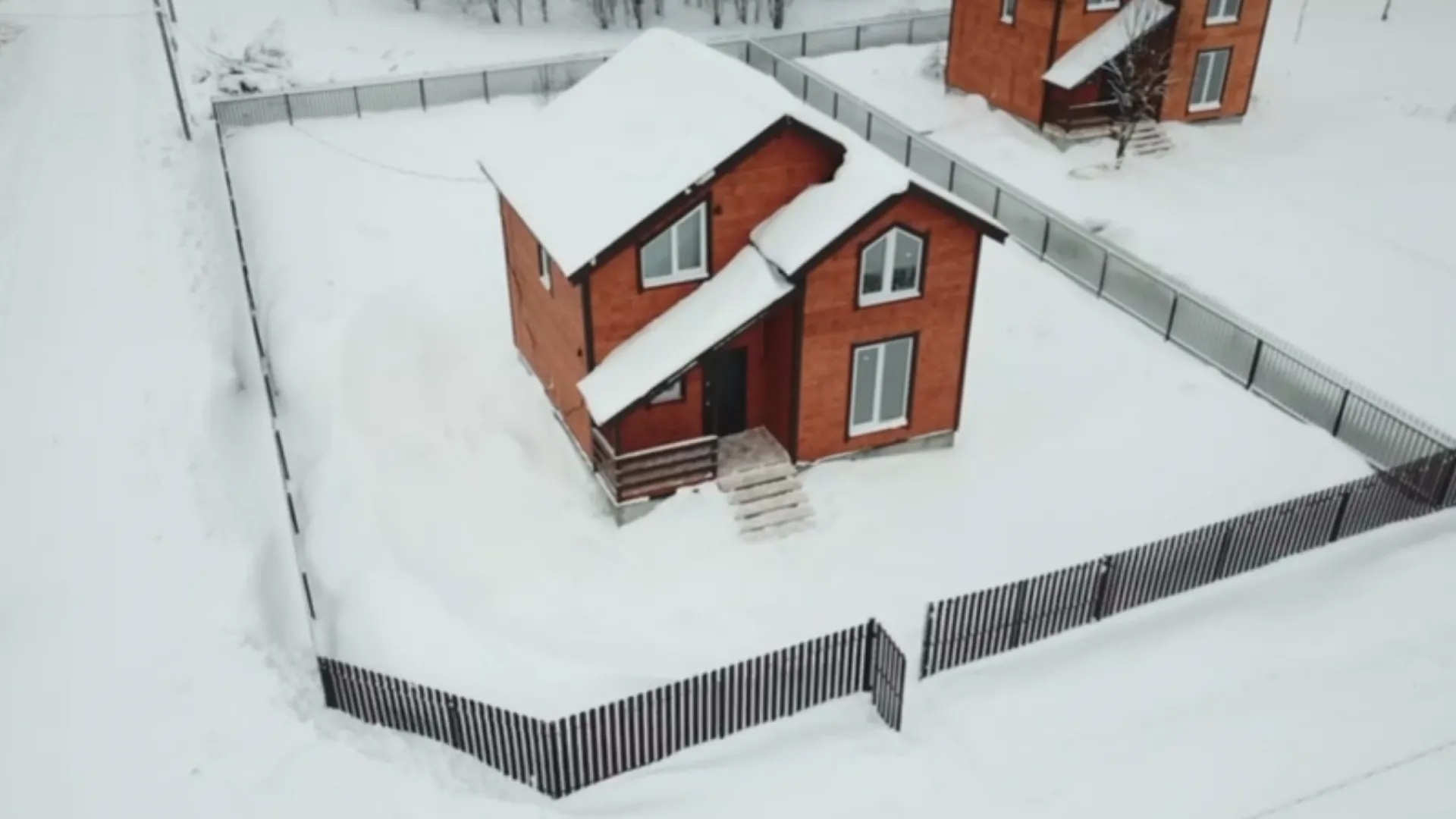 Дом с забором зимой